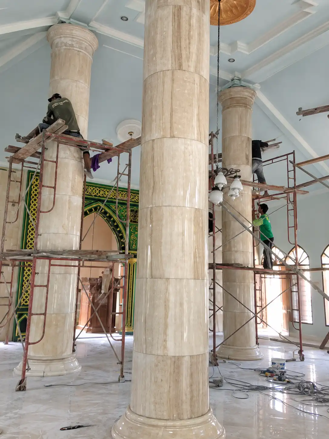 Pemasangan pelapis tiang onyx marmer di masjid dengan perancah